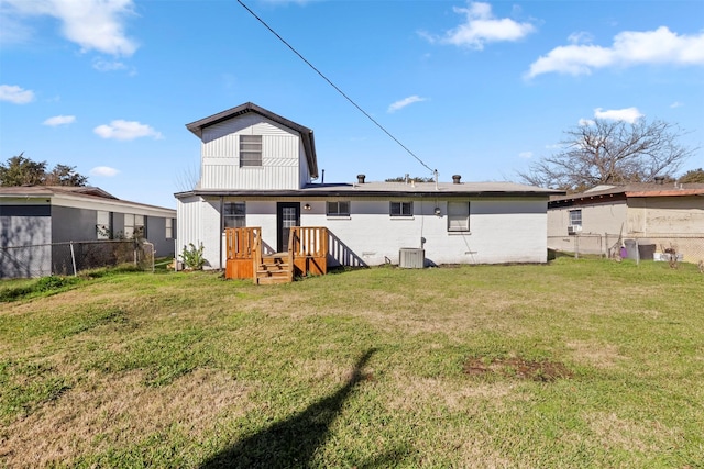 rear view of house with a lawn and central AC