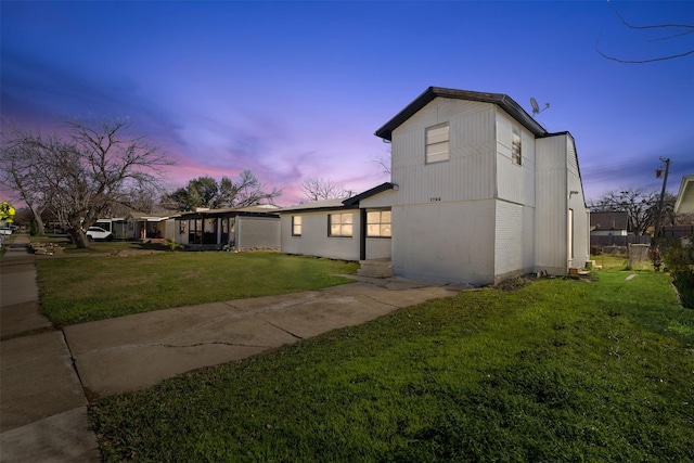 property exterior at dusk with a lawn