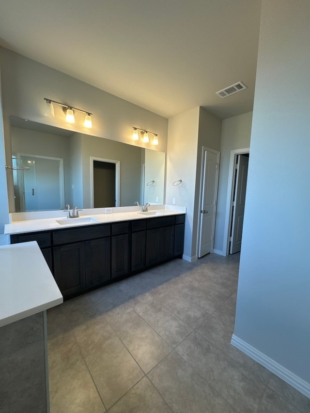 full bathroom featuring double vanity, a sink, visible vents, and baseboards