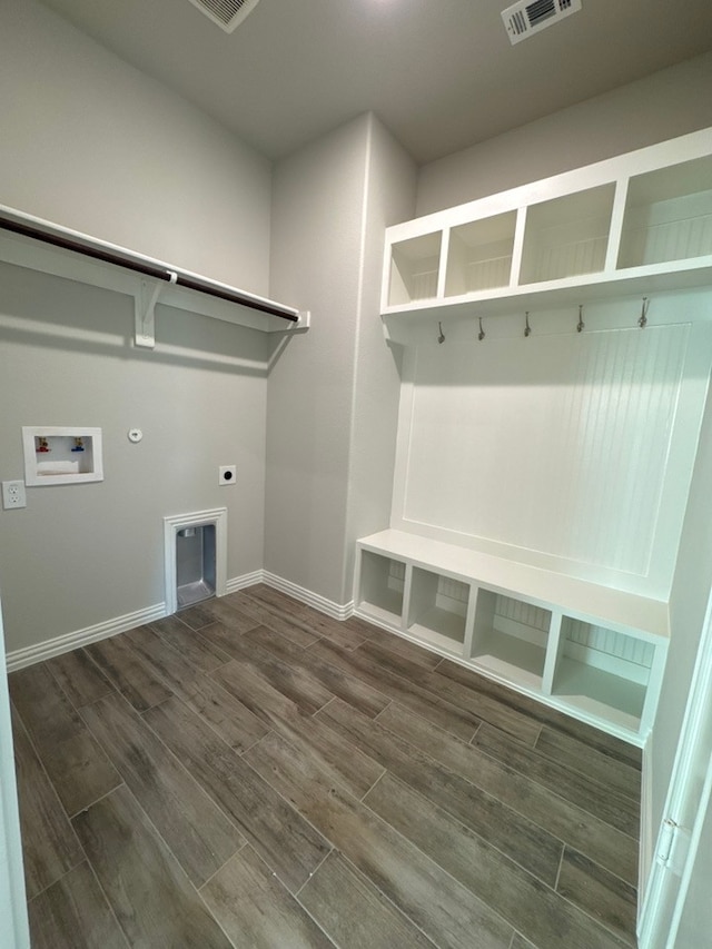 mudroom featuring wood finish floors, visible vents, and baseboards