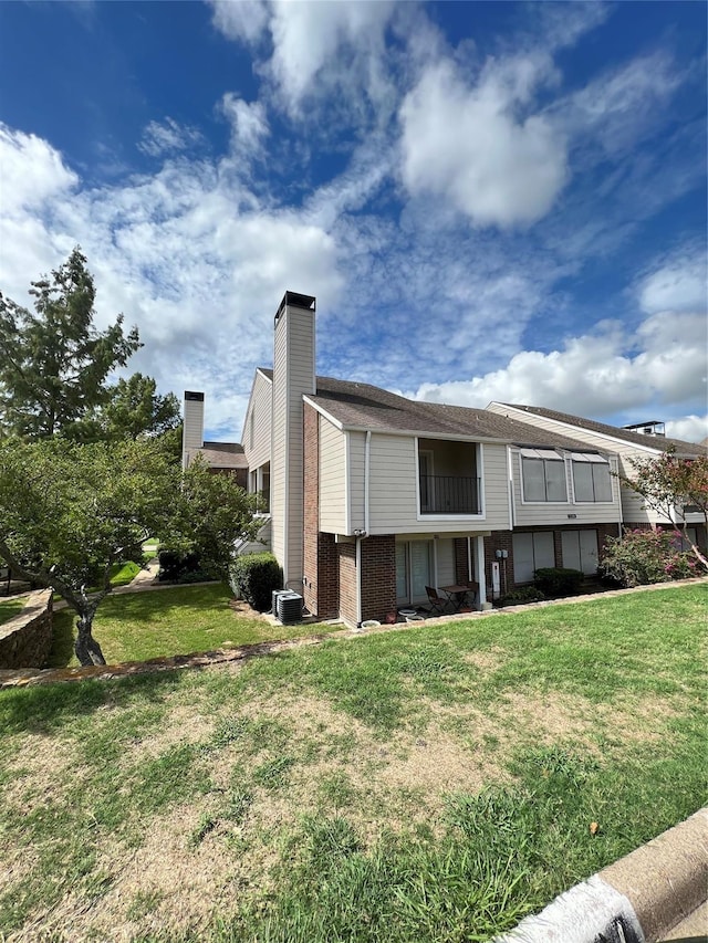 view of side of home with a lawn and cooling unit