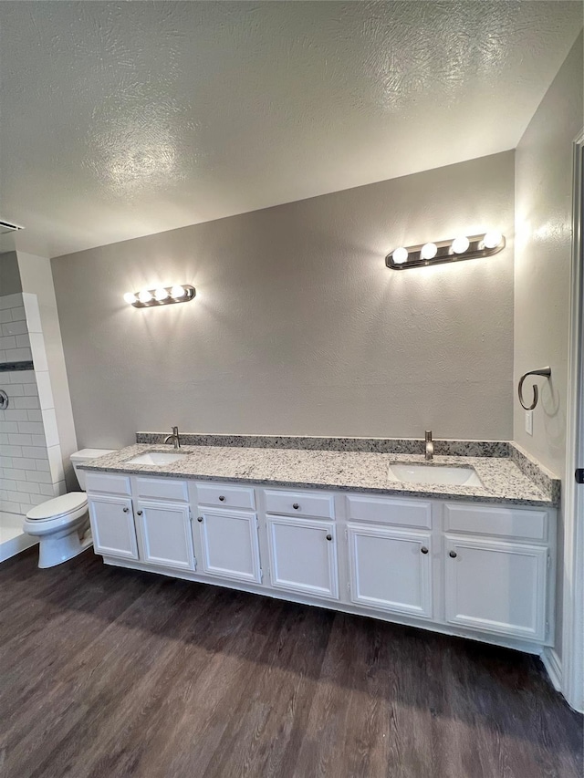 bathroom featuring hardwood / wood-style floors, vanity, a textured ceiling, and toilet