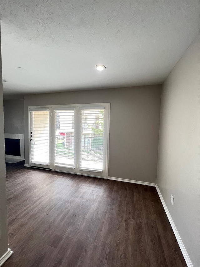 empty room featuring dark hardwood / wood-style flooring and a textured ceiling