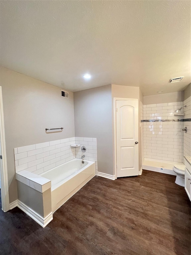 bathroom featuring wood-type flooring, a textured ceiling, toilet, and independent shower and bath