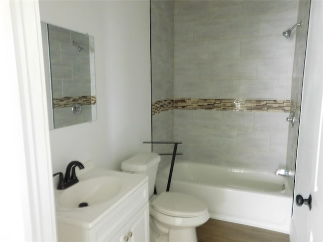 full bathroom featuring vanity, toilet, wood-type flooring, and tiled shower / bath