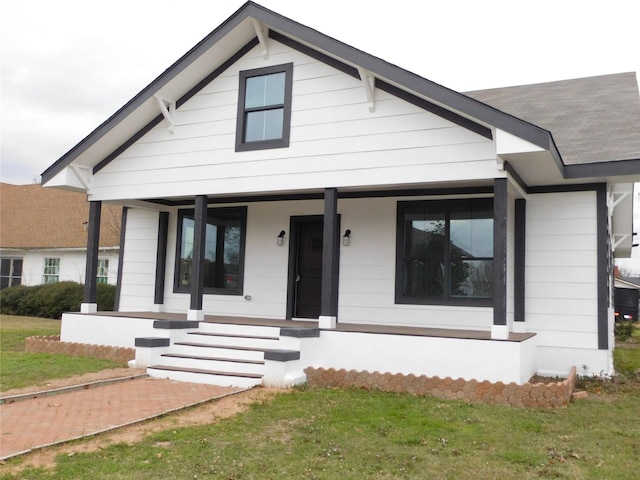 view of front of property featuring a front yard and covered porch