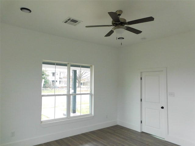 unfurnished room featuring ceiling fan, a healthy amount of sunlight, and dark wood-type flooring