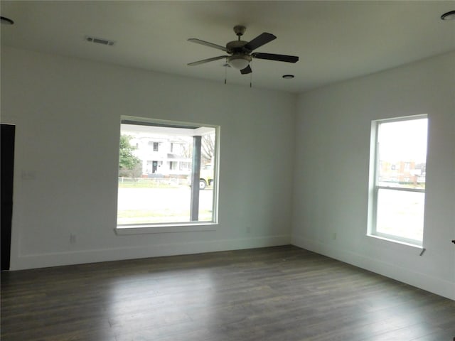 spare room featuring dark hardwood / wood-style floors, a healthy amount of sunlight, and ceiling fan