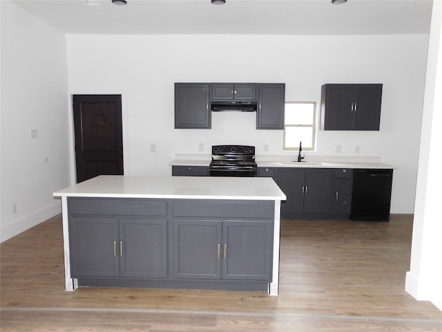 kitchen with sink, black appliances, light hardwood / wood-style flooring, gray cabinets, and a kitchen island