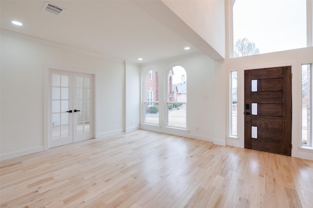 foyer featuring baseboards, french doors, visible vents, and light wood-style floors