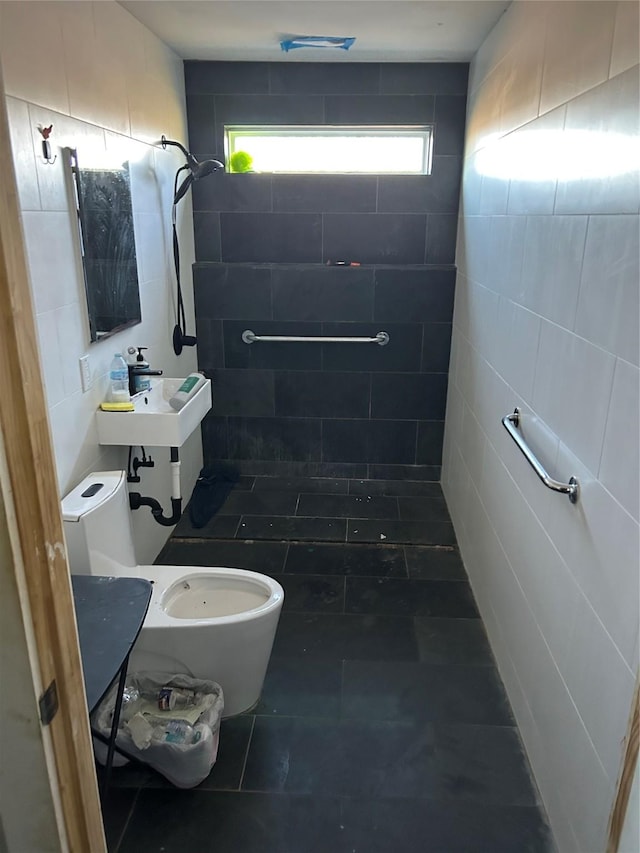 bathroom with toilet, sink, a wealth of natural light, and tile walls