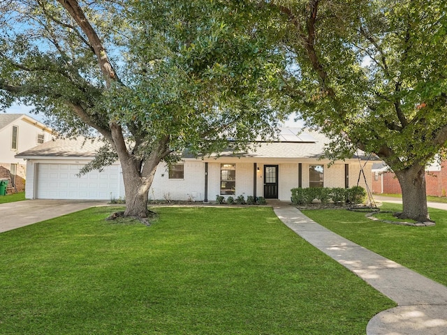 view of front of home featuring a garage, a front yard, and solar panels