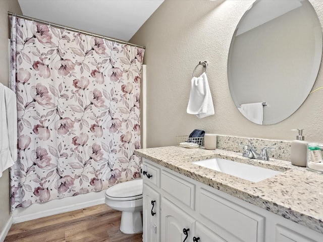 full bathroom featuring hardwood / wood-style floors, vanity, toilet, and shower / tub combo with curtain