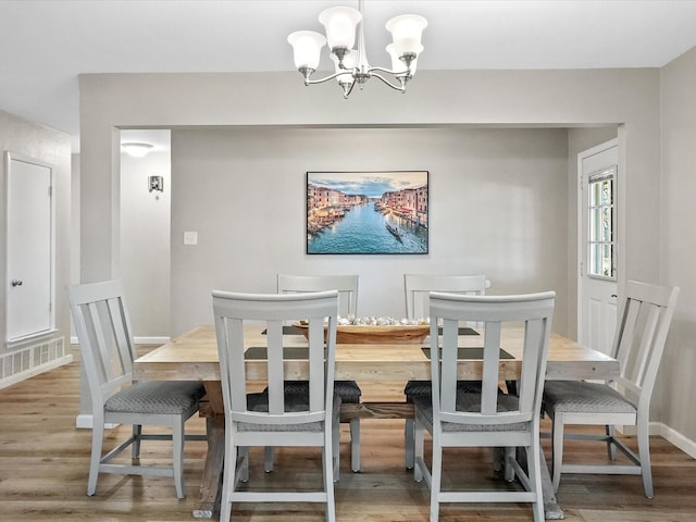 dining area featuring a chandelier and wood-type flooring