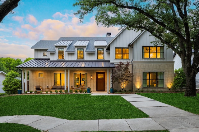 modern farmhouse with covered porch and a yard