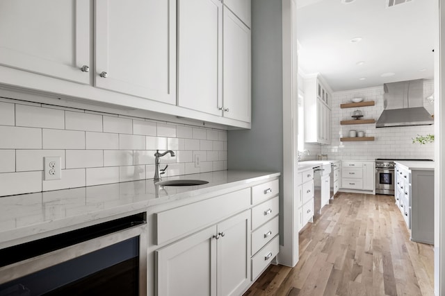 kitchen with white cabinets, tasteful backsplash, beverage cooler, and wall chimney exhaust hood