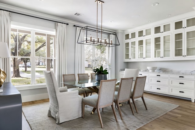 dining room with dark hardwood / wood-style flooring, ornamental molding, and an inviting chandelier