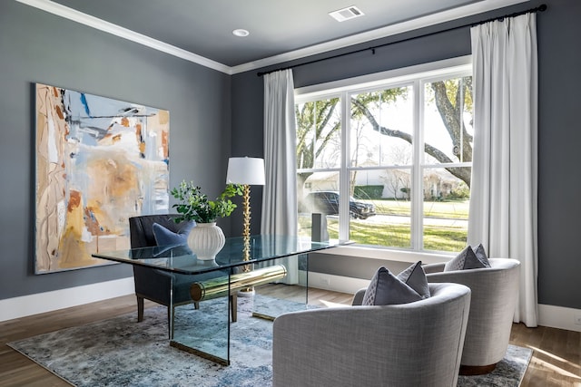 office space featuring a healthy amount of sunlight, wood-type flooring, and ornamental molding