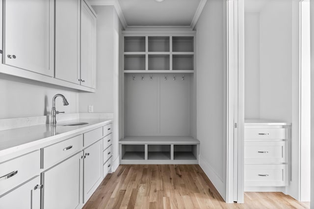 mudroom featuring crown molding, sink, and light wood-type flooring