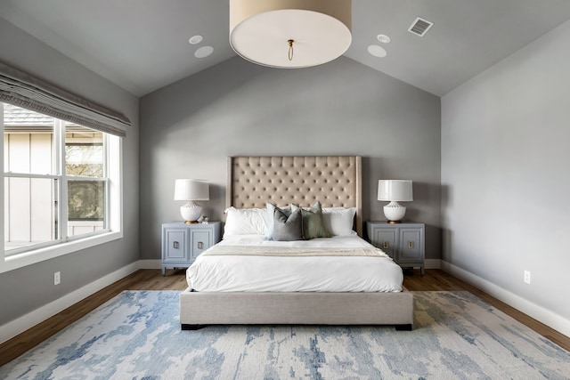 bedroom with hardwood / wood-style flooring and lofted ceiling