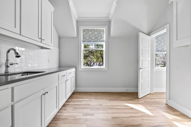 kitchen featuring decorative backsplash, sink, and white cabinets