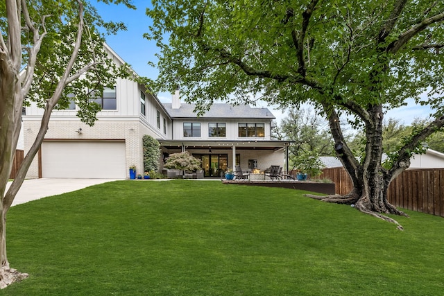 view of front of property with a garage, a front lawn, and a patio area