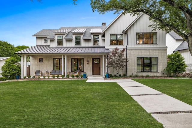 modern farmhouse featuring covered porch and a front lawn