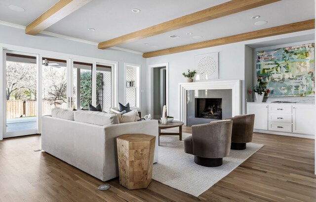 living room with beamed ceiling, dark hardwood / wood-style floors, and ornamental molding