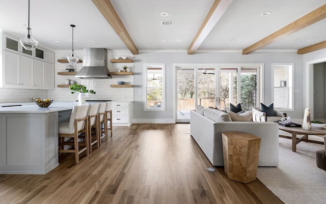 living room featuring beam ceiling and light wood-type flooring