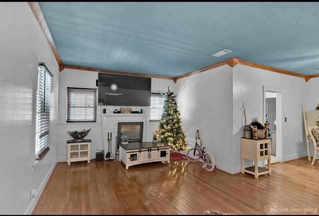 unfurnished living room with hardwood / wood-style floors and ornamental molding