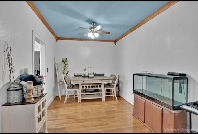 dining room with ceiling fan, light wood-type flooring, and ornamental molding