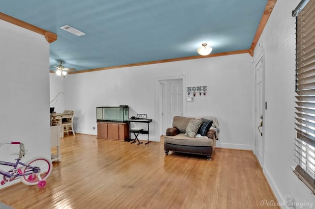 sitting room featuring crown molding, hardwood / wood-style floors, and ceiling fan