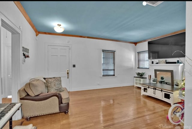 living room featuring light wood-type flooring and ornamental molding