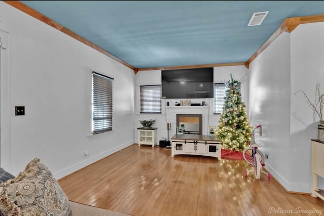 living room with light wood-type flooring and crown molding