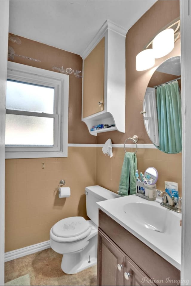 bathroom featuring vanity, tile walls, and toilet