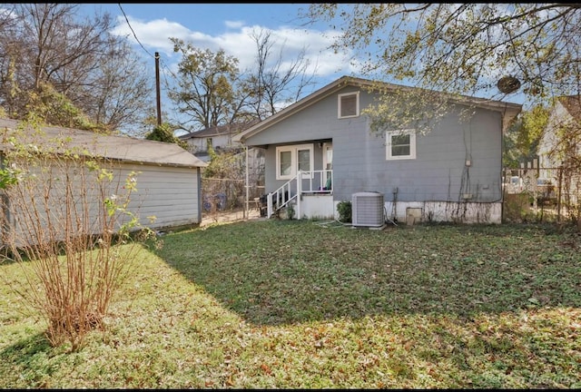 back of house featuring a yard and cooling unit