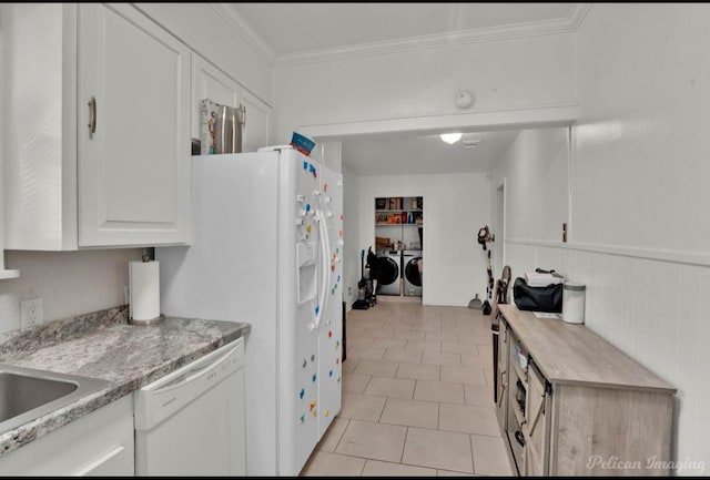 kitchen featuring white cabinets, white dishwasher, crown molding, washer and dryer, and light tile patterned flooring