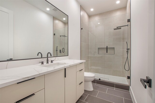 bathroom featuring tile patterned floors, vanity, toilet, and an enclosed shower