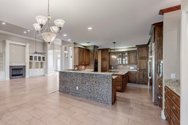 kitchen featuring kitchen peninsula, tasteful backsplash, ceiling fan with notable chandelier, crown molding, and decorative light fixtures