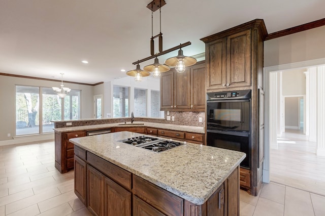 kitchen featuring sink, a center island, decorative light fixtures, and appliances with stainless steel finishes