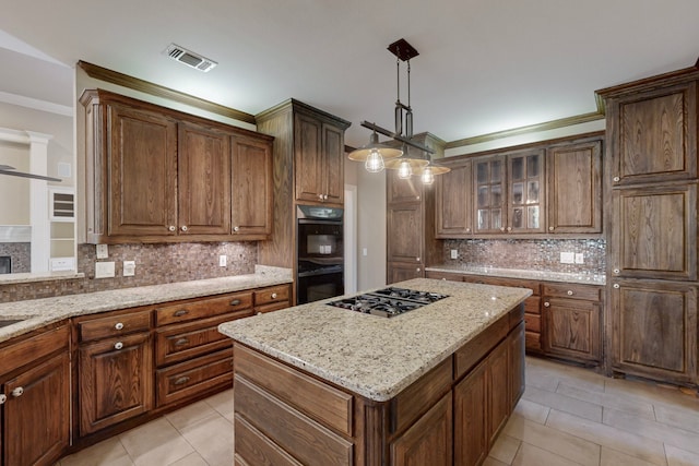 kitchen with black double oven, stainless steel gas cooktop, light tile patterned floors, decorative light fixtures, and a center island