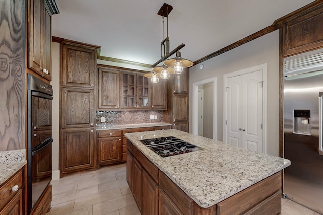 kitchen featuring appliances with stainless steel finishes, crown molding, decorative light fixtures, a kitchen island, and light tile patterned flooring