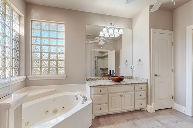 bathroom with tile patterned floors, ceiling fan, vanity, and a bath