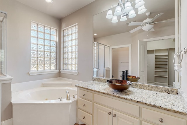 bathroom featuring vanity, separate shower and tub, and ceiling fan