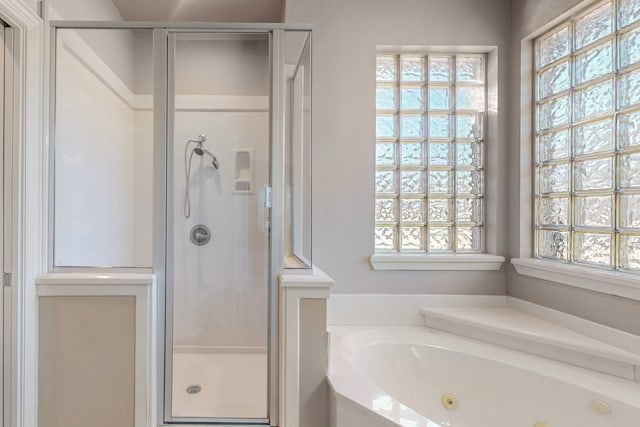 bathroom featuring a wealth of natural light and independent shower and bath