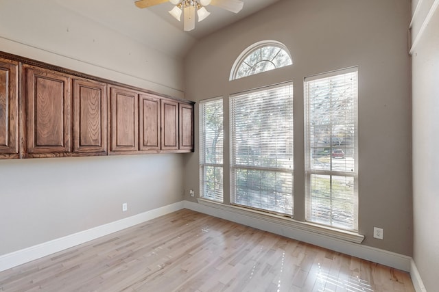 unfurnished room with ceiling fan, light wood-type flooring, and lofted ceiling