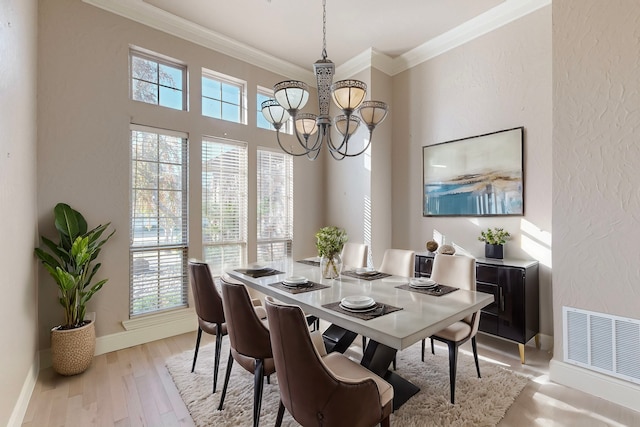 dining area featuring a chandelier, light hardwood / wood-style flooring, and ornamental molding