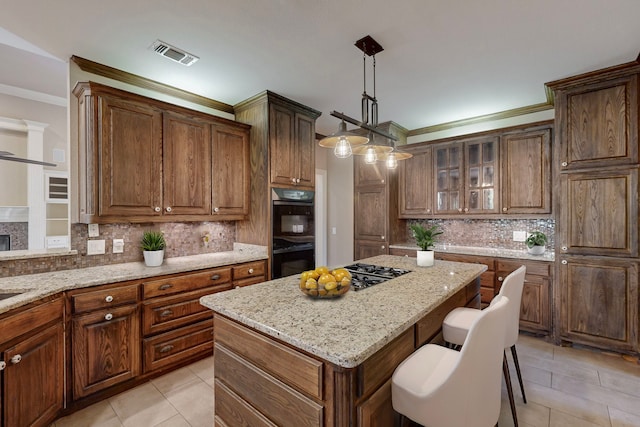 kitchen featuring pendant lighting, a center island, black double oven, and tasteful backsplash