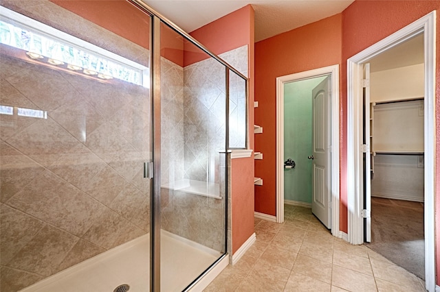 bathroom featuring tile patterned floors and a shower with door