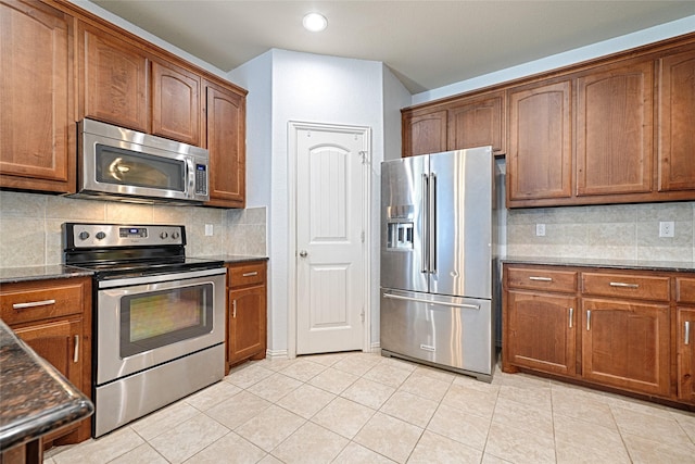 kitchen featuring backsplash, light tile patterned flooring, and appliances with stainless steel finishes